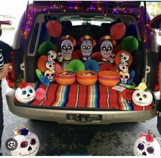 the trunk of a car decorated with sugar skulls and mexican day of the dead decorations