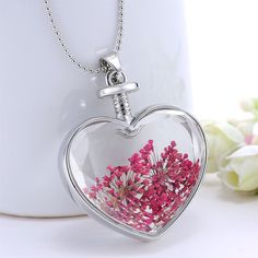 Enjoy the blooms year round with this heart-shaped pendant necklace showcasing pressed flowers set in resin and strung from a silvertone chain. Chain: 23.62'' L Pendant: 1.42'' W x 1.65'' L Lobster claw clasp Silvertone copper / pressed flower / resin White Heart-shaped Jewelry With Pressed Flowers, White Heart Jewelry With Pressed Flowers, Silver Flower Necklace For Valentine's Day, Valentine's Day Silver Flower Pendant Necklace, Heart-shaped Necklace With Pressed Flowers For Mother's Day, Mother's Day Heart Pendant Necklace With Pressed Flowers, Heart-shaped Jewelry With Pressed Flowers For Valentine's Day, Valentine's Day Heart Pendant Necklace With Pressed Flowers, Valentine's Day Pressed Flowers Heart Pendant Necklace