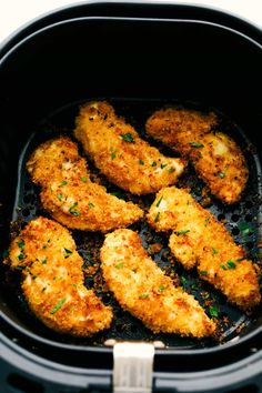 fried chicken in an air fryer with parsley on the top, ready to be cooked