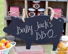 a sign that says baby jack's bbq next to some fruit and vegetables