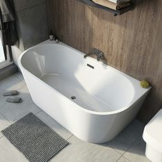 a white bath tub sitting on top of a bathroom floor next to a toilet and sink