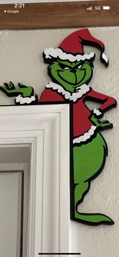 the grinch is hanging on the wall