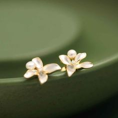 Why We Made This Our White Lilac Flower Earring Studs are a perfect blend of simplicity and elegance. These tiny yet elegant earrings capture the essence of purity and innocence, symbolized by the white lilac flower. The delicate design, combined with the symbolic meaning of the white lilac, makes these earrings a thoughtful and stylish accessory. The freshwater pearl and sparkling zircon add a touch of sophistication, making them suitable for both casual and formal occasions. Product Details MA White Classic Flower Earrings For Pierced Ears, Classic White Flower Earrings For Pierced Ears, White Classic Flower Earrings For Anniversary, White Classic Flower Earrings, Classic White Flower Earrings For Anniversary, Classic White Flower Earrings, Elegant Flower Shaped Hypoallergenic Earrings, Dainty Flower Earrings For Formal Events, White Dainty Pearl Earrings For Pierced Ears