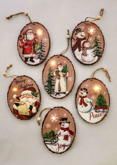 four christmas ornaments with santa and snowmen on them