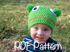 a little boy wearing a green crocheted frog hat