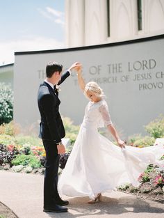 a bride and groom dancing in front of the church of jesus christ's approval