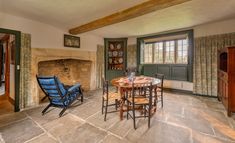 a dining room table and chairs in front of a fireplace