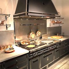 a large kitchen with stainless steel appliances and counter tops on both sides of the stove