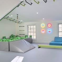 a room with white walls, green and blue decorations on the wall, and a couch in front of a window