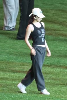 a woman walking across a lush green field