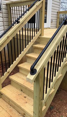 a wooden staircase with black railing and hand rail