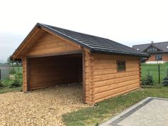 a small wooden garage with a black roof