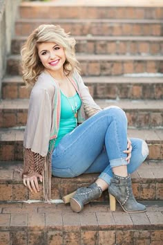 a woman sitting on some steps with her legs crossed