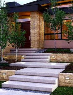 a house with steps leading up to the front door and trees on either side of it