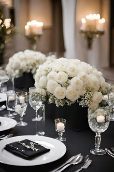 a table set with white flowers and silverware