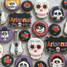 decorated cookies with the names of different kinds of sugar skulls and guitars are displayed on a table