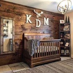 a baby's room decorated in rustic wood with deer head and name on the wall