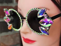 ADULT sized new round/circle sunglasses with metal frames and dark lenses, accented by an array of clear iridescent twinkling rhinestones. These stones are faceted and mounted in silver colored settings, giving them a fantastic sparkle in any light. These bedazzled beauties offer bold and exciting looks for sunny days. Custom colors, styles, and frames available by request.  These glasses offer UV 400 protection. Iridescent Sunglasses, Luxury Multicolor Sunglasses With Mirrored Lenses, Multicolor Glass Sunglasses For Festivals, Silver Rhinestone Sunglasses With Glass Lenses, Diy Sunglasses, Circle Sunglasses, Plastic Cat-eye Sunglasses With Mirrored Lenses, Rainbow Iridescent, Sunglasses Round