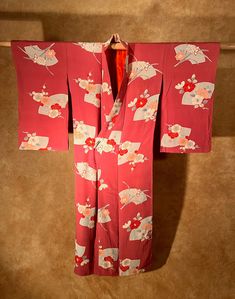 "It is an antique silk kinsha kimono. The color is darker pink and crimson than red. It is very soft to the touch. A variety of flowers are scattered throughout and it is a design unique to antiques. It is a very lovely kimono. The overall condition is good, there is a little color unevenness around the front left hem, back middle, and front right sleeve, but it is not very noticeable.  Most of our Kimonos and Haoris are hand sewn and custom made. We measure from sleeve edge- to-edge (horizontal Traditional Pink Kimono For Spring, Elegant Red Kimono For Spring, Pink Silk Kimono For Wedding, Pink Silk Long Sleeve Kimono, Elegant Red Spring Kimono, Pink Silk Wedding Kimono, Red Vintage Kimono For Spring, Vintage Red Long Kimono, Vintage Long Red Kimono