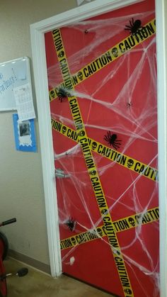 a door decorated with caution tape and spider webs