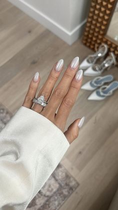 a woman's hand with white manies and a diamond ring on her finger