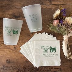 napkins and cups on a wooden table with flowers