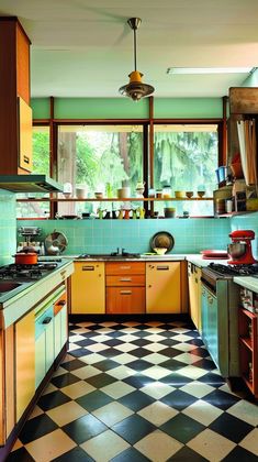 an old fashioned kitchen with checkered flooring and yellow cabinets, including stove top oven