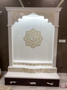 an ornate white and gold display case in a room with other items on the floor