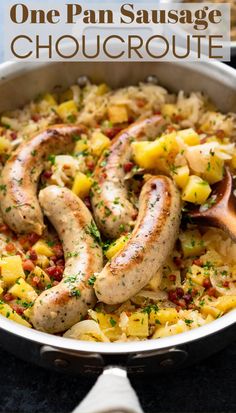 sausage and pineapple paella in a pan with a wooden spoon on the side