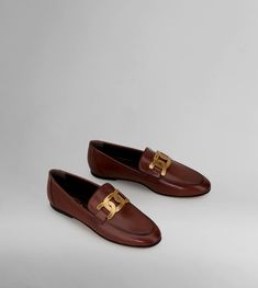 Loafers in elegant, brushed leather and a smoky-effect finish, with a metal branded, chain accessory and a leather outsole. Luxury Loafers With Metal Feet For Galas, Elegant Leather Loafers With Metal Logo, Formal Leather Loafers With Metal Logo, Luxury Leather Loafers With Metal Feet, Luxury Leather Shoes With Metal Feet For Formal Occasions, Brown Loafers, A Metal, Leather Upper, Dust Bag