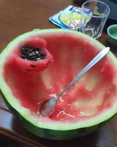 a watermelon that has been cut in half with a spoon