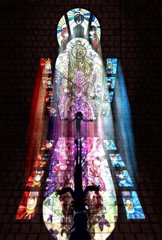 a large stained glass window in the middle of a room with lights coming from it