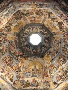 an ornate ceiling with paintings on it and a round window in the center is shown