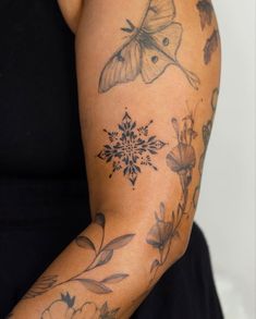 a woman's arm with tattoos on it and a butterfly tattoo on the arm