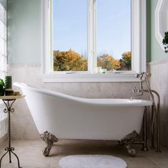 a bath tub sitting next to a window in a bathroom