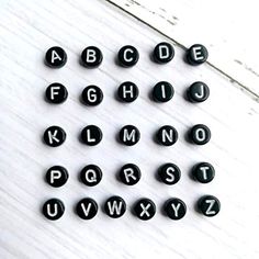 black and white alphabets are arranged on a wooden surface