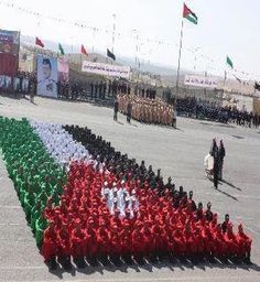 a group of people in red and white outfits standing next to each other with flags on them