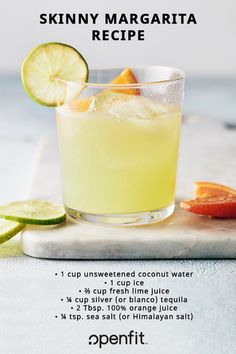 a glass filled with lemonade next to sliced oranges and lime