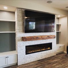 a flat screen tv mounted on the wall above a fireplace