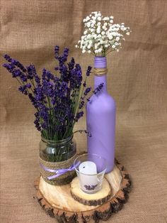 purple vases with lavender flowers and candles on a wood slice