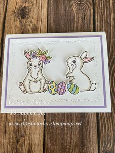 a card with two rabbits and an easter egg on it, sitting next to each other