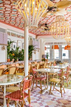 the inside of a restaurant with many tables and chairs