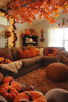 a living room filled with furniture and lots of pumpkins hanging from the ceiling above