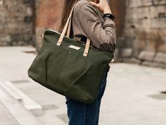 This personalised canvas shoulder bag for woman is both functional and stylish with a nice green khaki color. Pack it for a quick overnight trip, use it as an airplane carry on luggage, for your laptop, or even off to college in style! This large capacity canvas tote Bag also is the perfect size to use as a shopper bag for new moms! It is made with recycled canvas. The custom laptop bag has a zip top closure, and two external pockets. The Straps are portuguese cork in natural color and all hardw Recycled Handbag, Airplane Carry On, Convertible Tote Bag, Black Rucksack, Tote Bag With Pockets, Bag With Pockets, Vegan Tote Bag, Tote Bags For School, Off To College