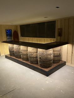 three wooden barrels sitting on top of a counter in a room with wood paneling