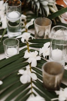 the table is set with white flowers and candles