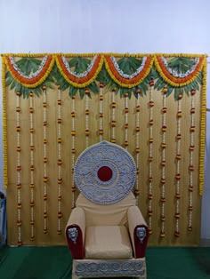 a chair sitting in front of a wall decorated with flowers and garlands on it