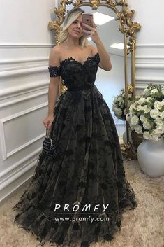 a woman taking a selfie in front of a mirror wearing an off the shoulder black dress