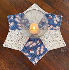 a candle is sitting on top of a napkin with a blue and white pattern around it