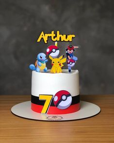 a pokemon themed birthday cake with the number seven on it and five pikachu figurines